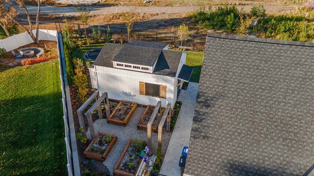 15x21 backyard standalone golf simulator studio in Draper, Utah built by Solitude Custom Sheds featuring double French doors and natural wood accents; perfect for year-round indoor golf practice, backyard offices, or gym studios.