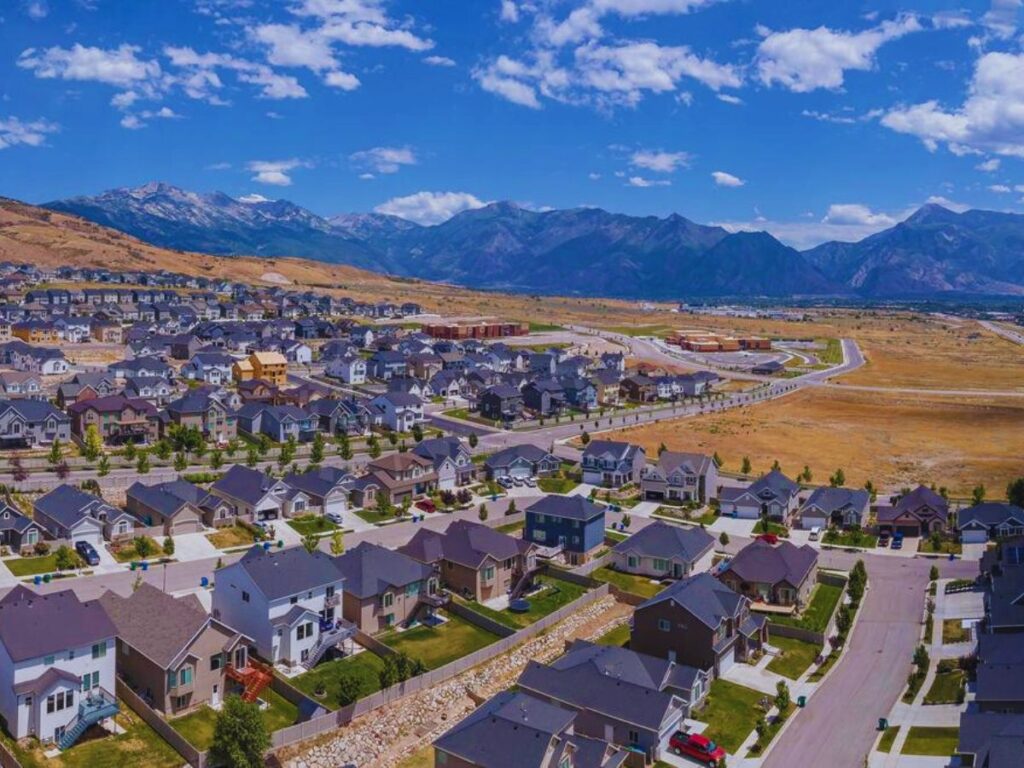 Aerial view of houses with mountains and blue sky background, Lehi, UT