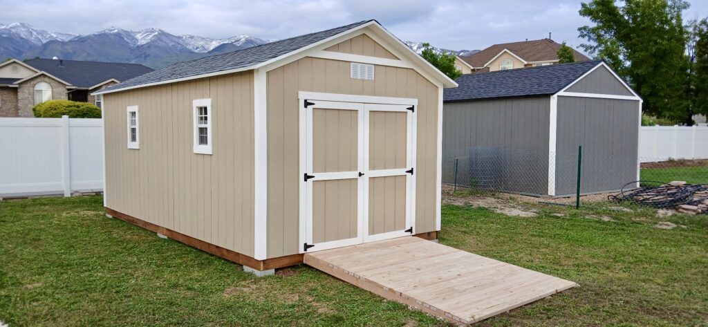 10x19 custom outdoor storage shed with 8' walls built by Solitude Custom Sheds in Kaysville, Utah; featuring a modern tan exterior, 5' double doors, and an extra wide ramp for backyard tools and lawn equipment storage.