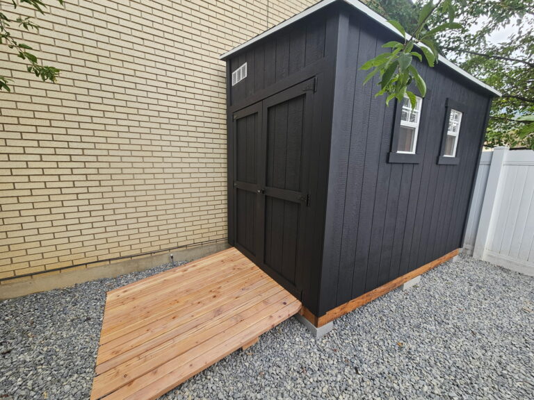 6x10 lean-to outdoor storage shed built by Solitude Custom Sheds in Sandy, Utah; featuring designer exterior paint, custom double doors, ramp, and premium craftsmanship for backyard storage or workshop use.Custom painted 6x10 lean-to outdoor storage shed in Sandy, Utah built by Solitude Custom Sheds featuring black siding, double doors, and a wooden ramp on gravel base