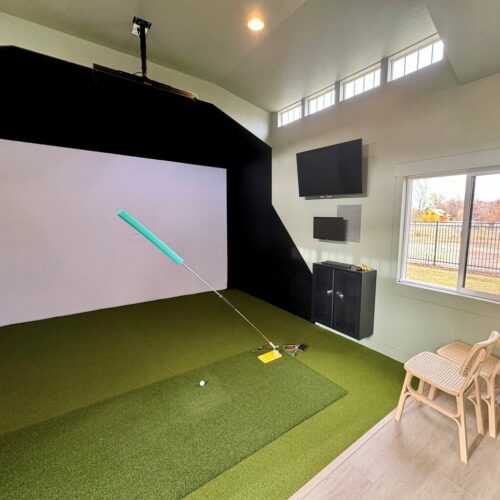 Interior of a custom golf simulator studio built by Solitude Custom Sheds in Draper, Utah, featuring modern wall finishes, and natural light from transom and vinyl windows. Ideal for year-round home golf practice or a stylish backyard office.