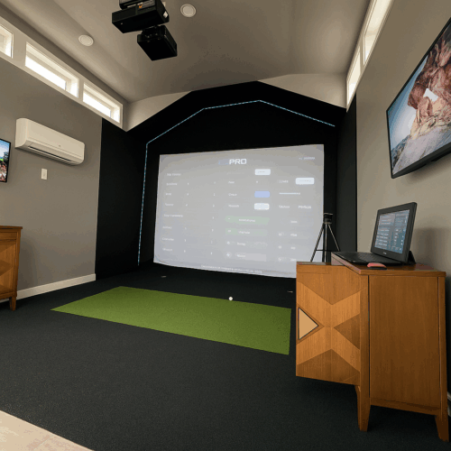 Interior view of a custom golf simulator studio shed in Herriman, Utah featuring a Uneekor launch monitor, impact screen, turf hitting mat, and modern climate-controlled design by Solitude Custom Sheds.